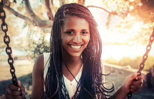 happy african girl swinging outdoors